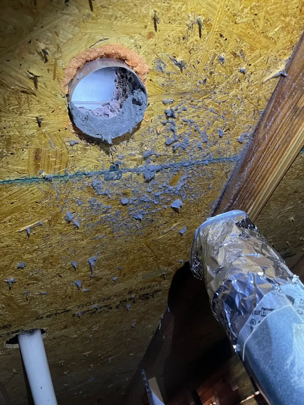 A framed vent opening cut through the insulation and sheathing of a Simpsonville attic