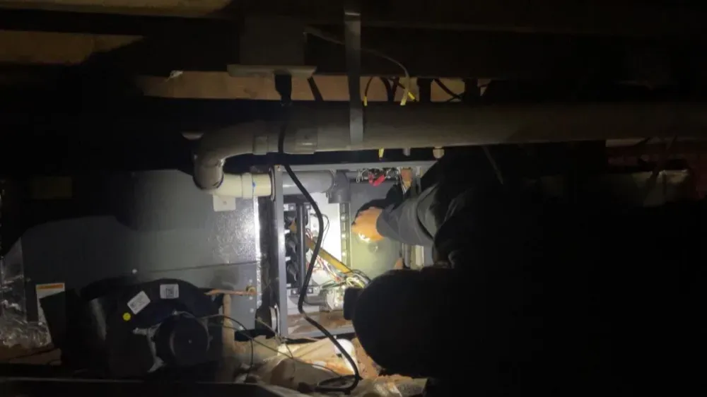 A work light aimed at an air handler during a crawl space repair in Simpsonville