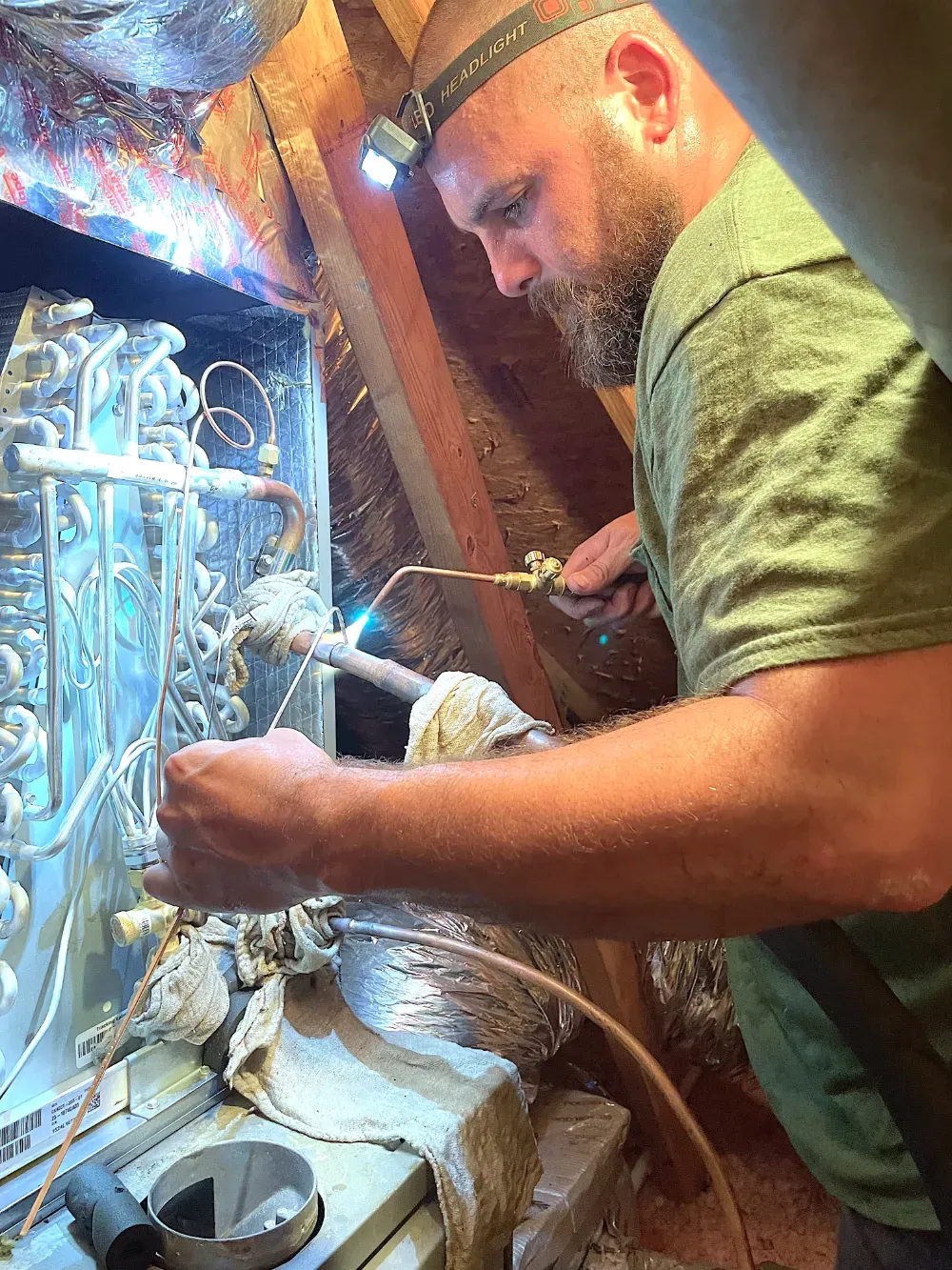 A Rhino HVAC technician brazing at an evaporator coil in Fountain Inn