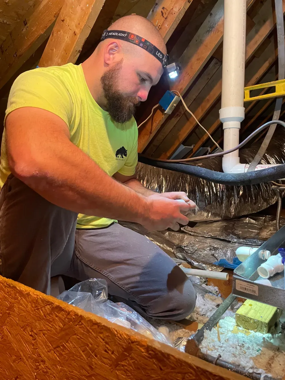 A Rhino HVAC technician sealing a PVC pipe joint in Fountain Inn
