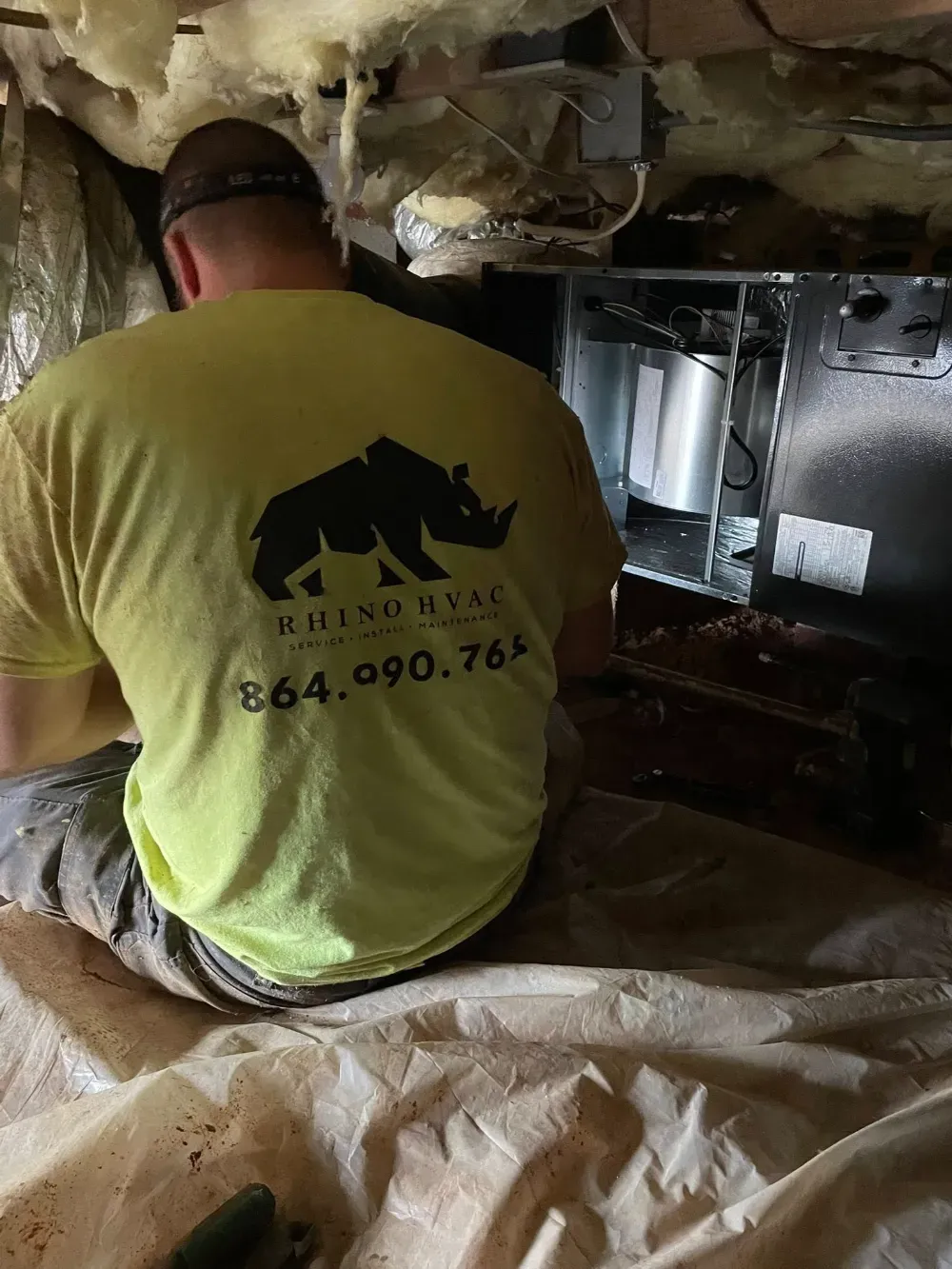 A Rhino HVAC technician servicing an equipment cabinet in a Simpsonville attic