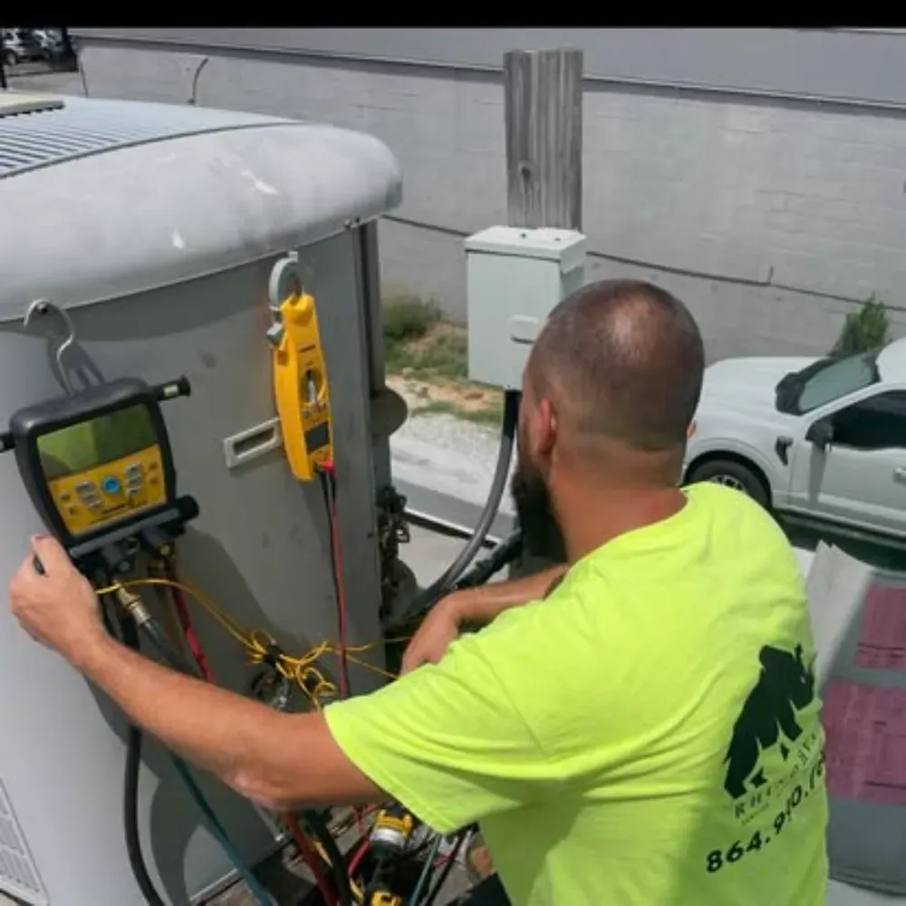 A Rhino HVAC technician testing a rooftop package unit in Simpsonville