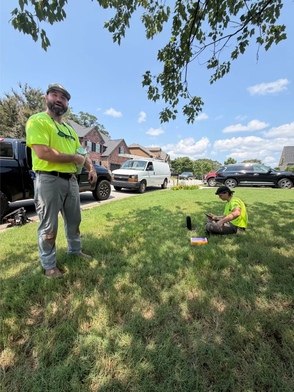 Two Rhino HVAC technicians taking a break in a Duncan yard between jobs